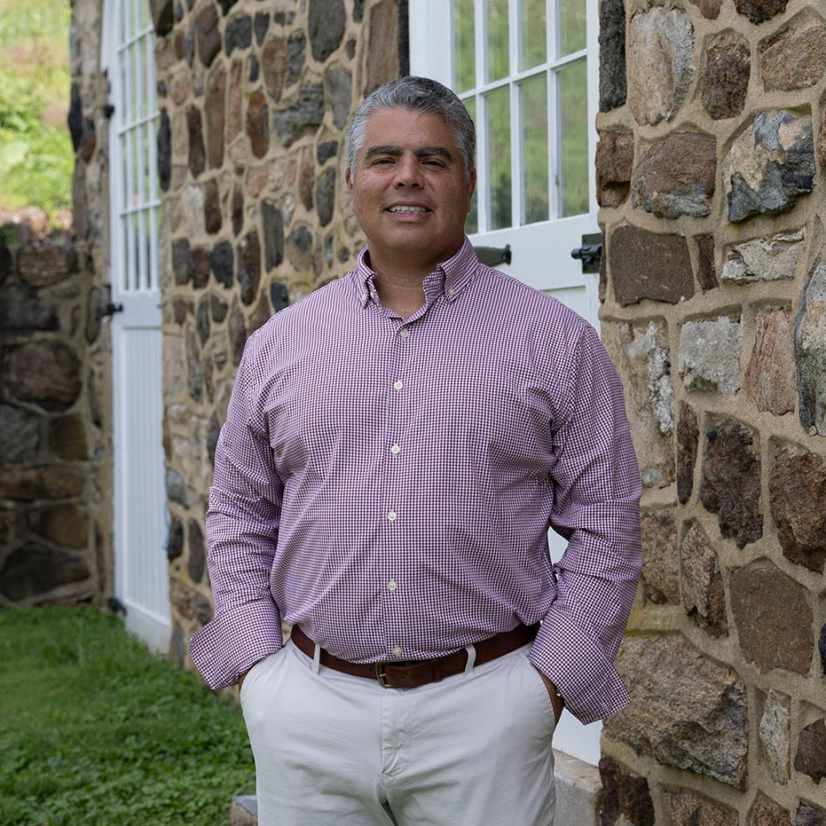 Greg Ranieri, Ranieri & Kerns founder, stands before a stone-facade home.