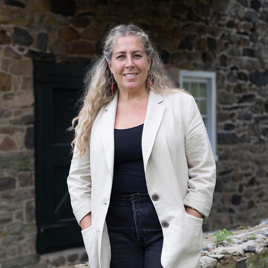 Gina Ranieri, Ranieri & Kerns managing partner, stands before a stone-facade home.
