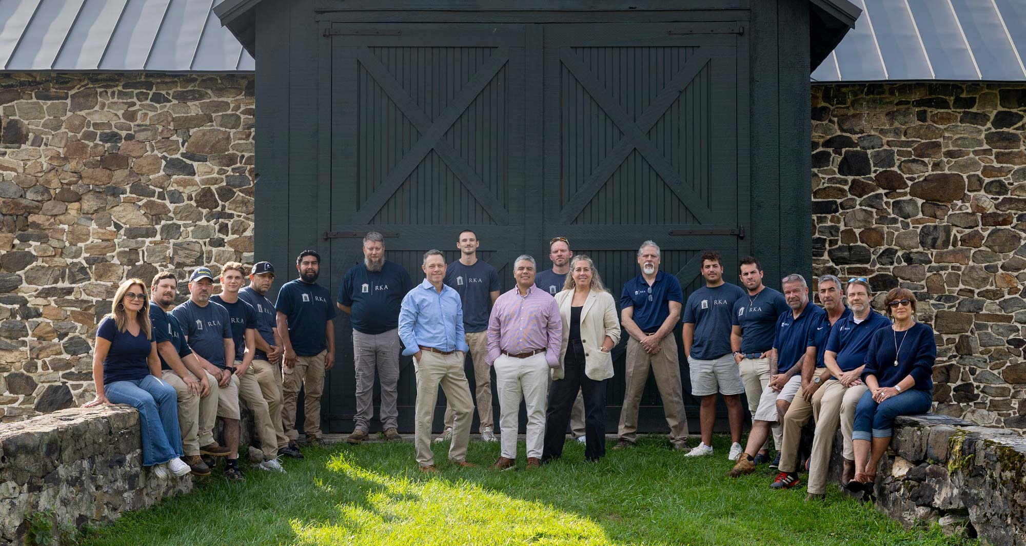 Ranieri & Kerns team in front of a stone barn facade.